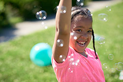 Photo of a child playing with bubbles.